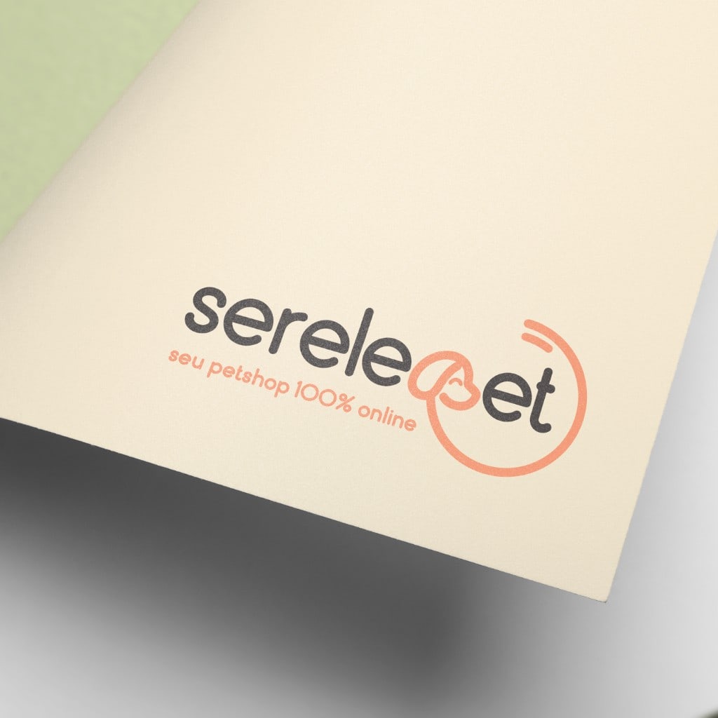 Close-up of the Serelepet logo printed on thick cream paper: lowercase charcoal wordmark with a coral circular dog icon around "pet", and the coral tagline "seu petshop 100% online" below.
