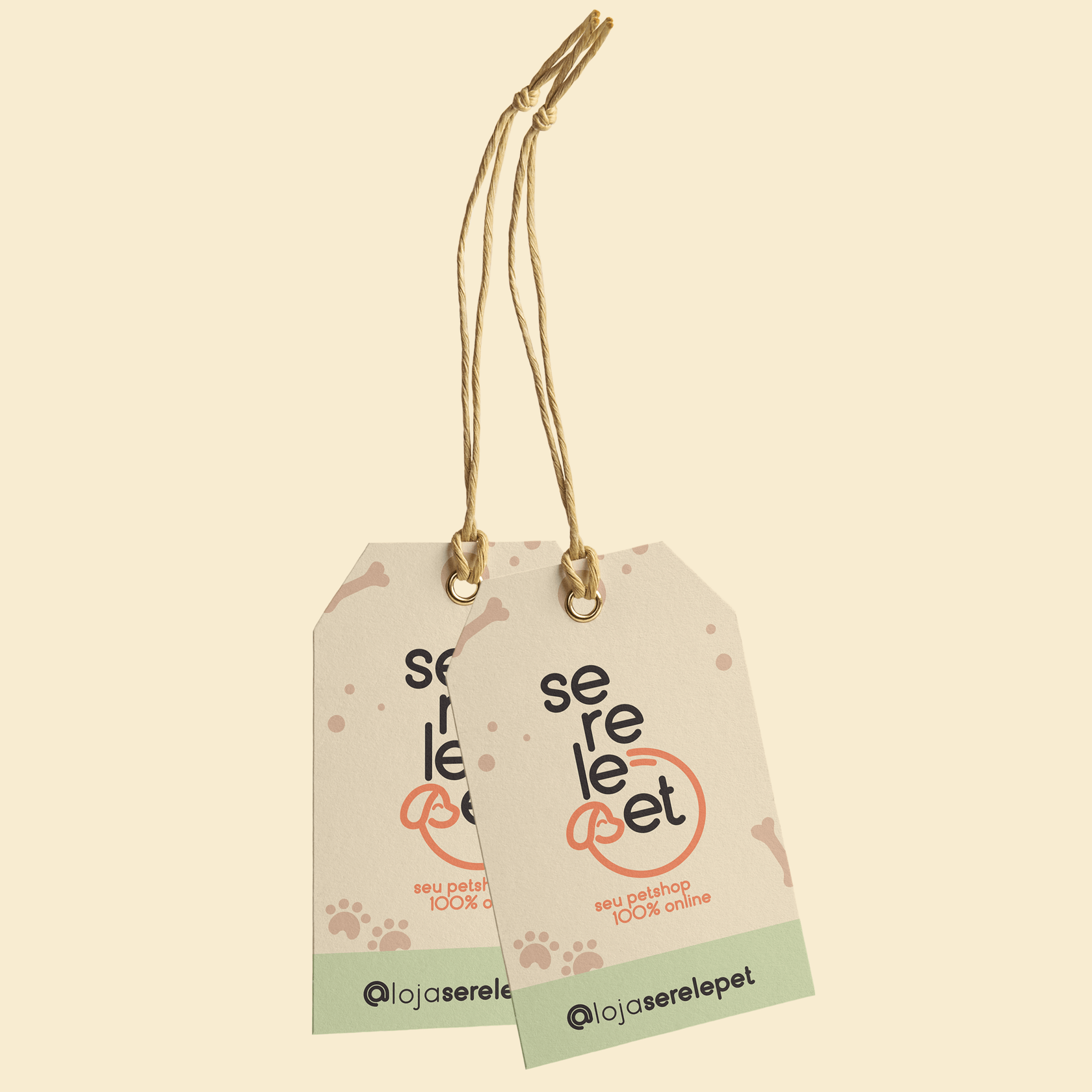 Two cream cardboard hang tags on twine showing the stacked Serelepet wordmark, the tagline "seu petshop 100% online" in coral, a mint strip with @lojaserelepet, and a light pattern of paws, dots, and a bone.